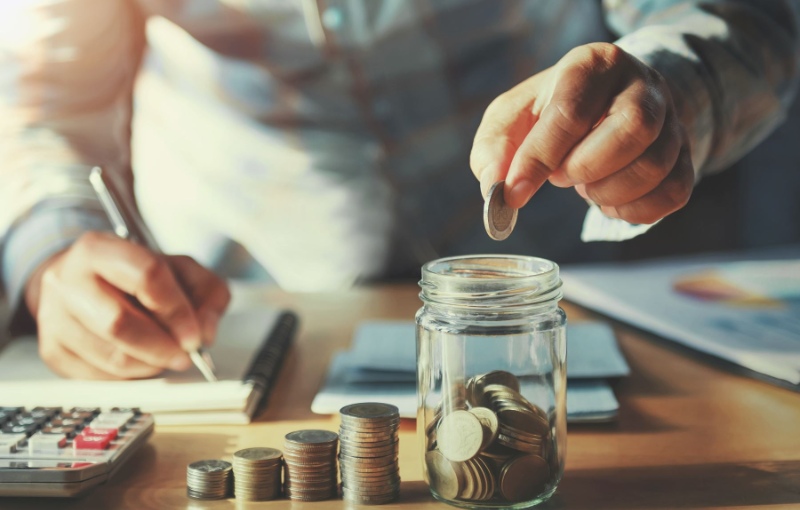 a person stacking coins in a jar