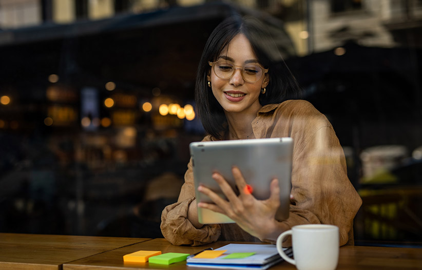 Young woman using tablet in coffee shop