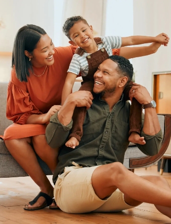 a family of three smiling in their new home