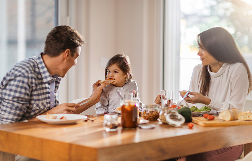 Young family eating dinner at table