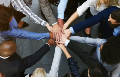 a group of professionals with their hands piled in the center