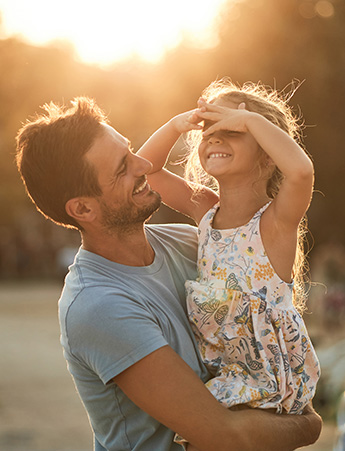 Father holding daughter outside