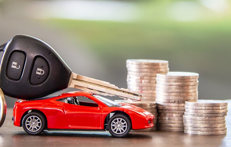 a model car besides a stack of coins and a key fob