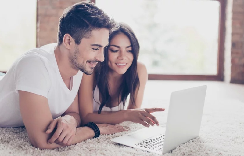 a man and a woman looking at their laptop computer