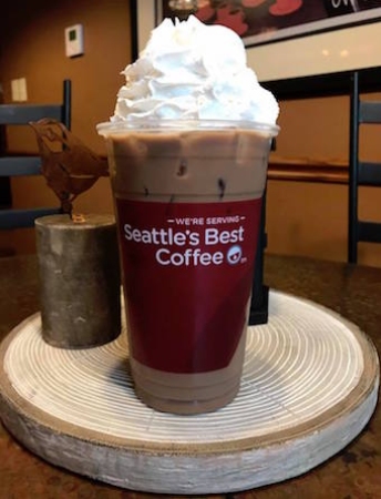 a cup of iced coffee topped with whip creame