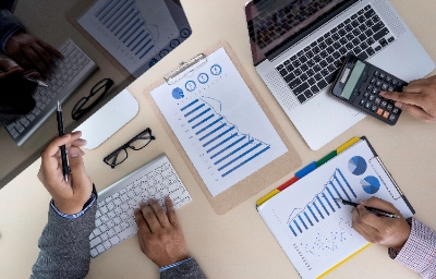 people calculating their finances using financial documents, calculator, desktop and laptop