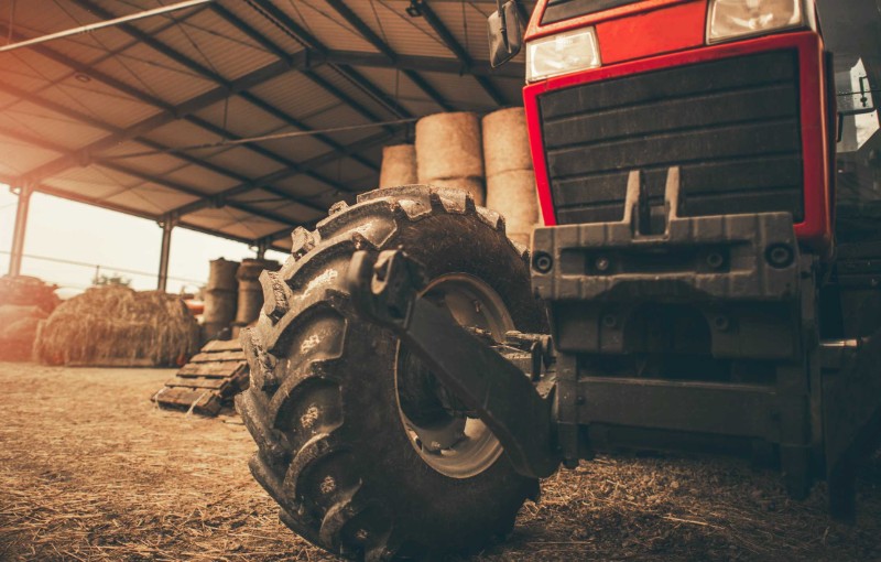 a red tractor housed in a barn