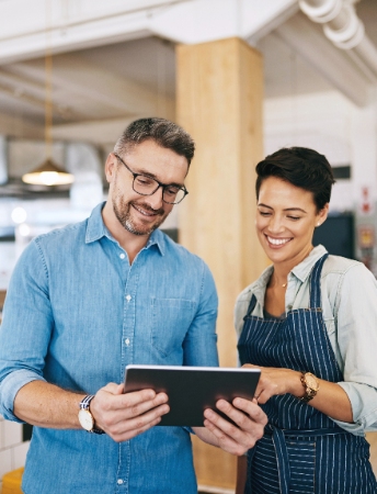 two small business owner reviewing items on a tablet